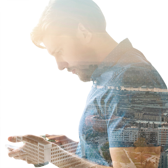 Reflection in window showing wide city vista of a man reminiscing on phone