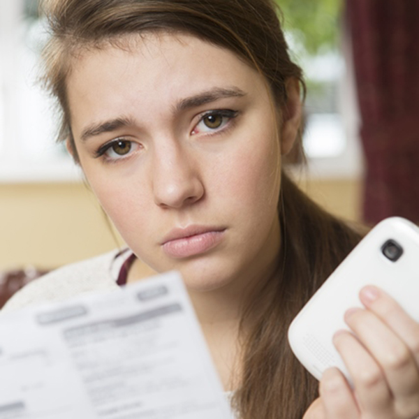 Young woman looking concerned about her mobil ebill 