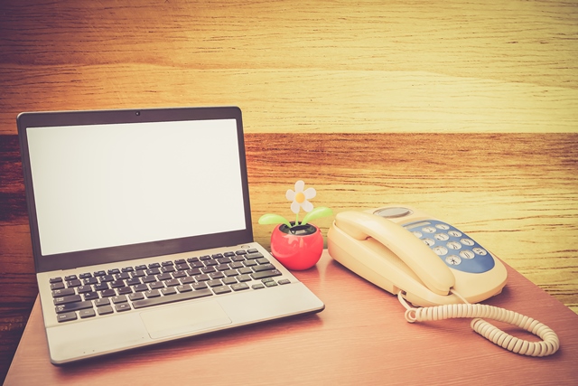 Laptop and landline phone on a desk