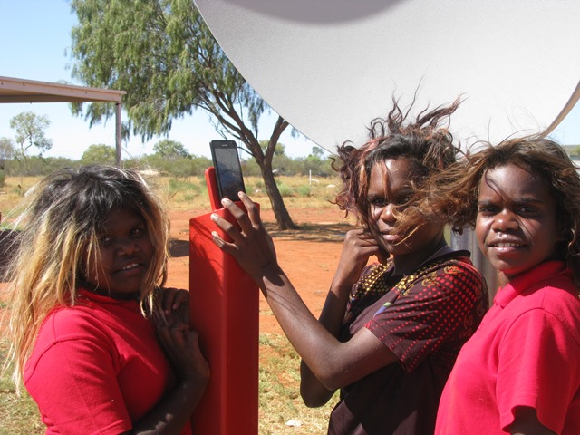 Three girls standing around mobile hotspot