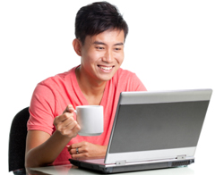 Picture of man holding coffee looking at laptop
