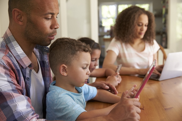 Family using tablets and laptop