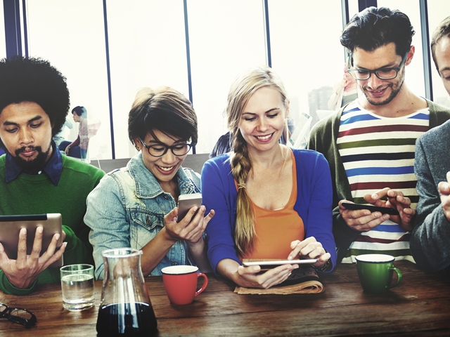 People at cafe using smartphones and tablets