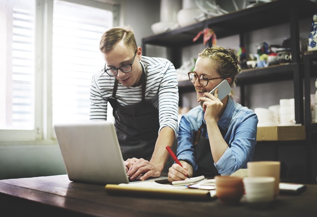 Small business operators using laptop and smartphone