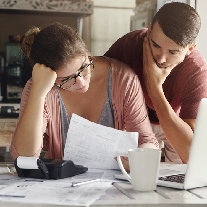 Man and woman looking at bill, distressed