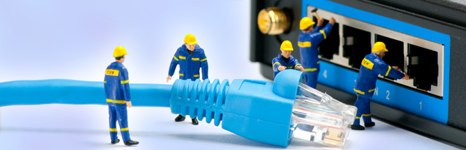 Toy workmen inserting a cable into a modem