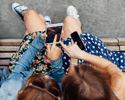 Teenage girls using smartphones