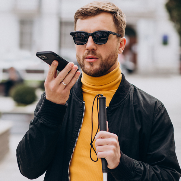 Man with mobility cane talks on phone