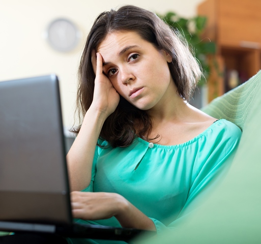 Sad woman using laptop