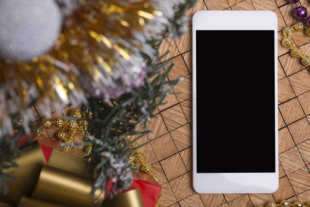 Smartphone next to Christmas tree