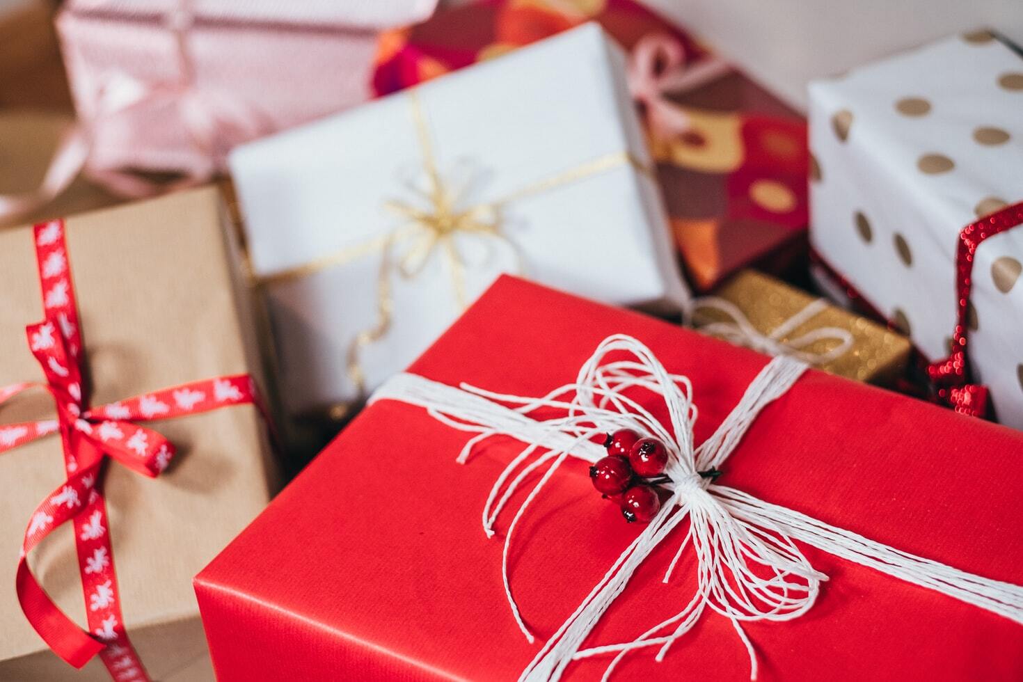 Christmas presents wrapped in red and white paper, under a Christmas tree